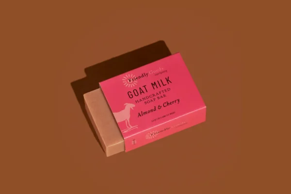 Almond & Cherry soap bar in wrapper against a dark brown background