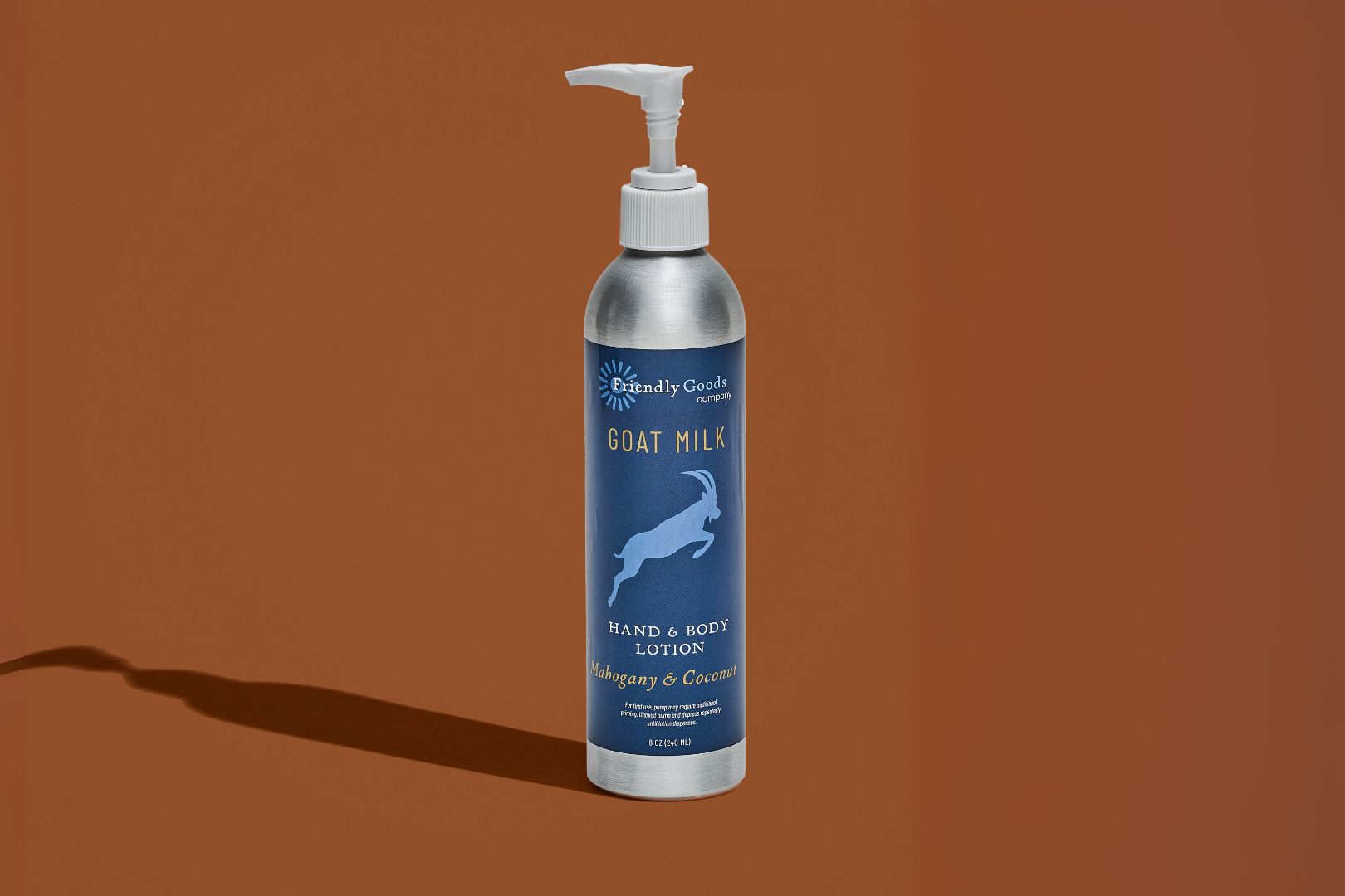 Mahogany & Coconut Goat Milk Lotion packaged product against a brown background with product shadow